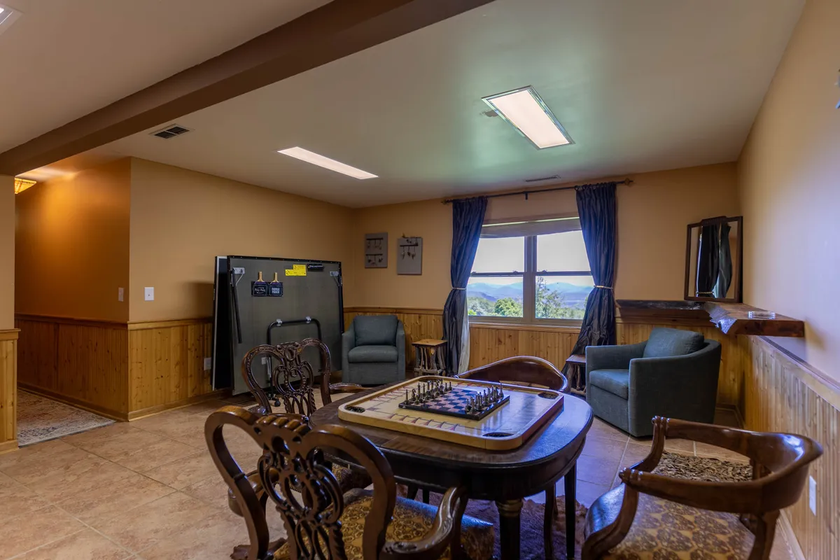 A friendly nook with a dedicated chess table, comfortable seating, and a view through the window, creating a perfect spot for strategic games, laughter, and relaxation. The room feels engaging and encourages both conversation and play.